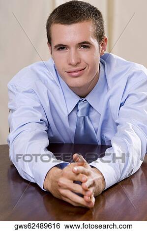 Portrait of a businessman leaning on a table View Large Photo Image Stock Photograph - Portrait of a businessman leaning on a table. Fotosearch