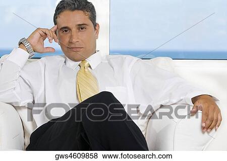 Portrait of a businessman sitting on an armchair View Large Photo Image Stock Photo - Portrait of a businessman sitting on an armchair. Fotosearch