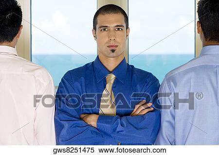 Stock Photography - Portrait of a businessman standing with two colleagues. Fotosearch