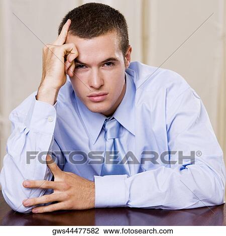 Portrait of a businessman with his hand on his temple View Large Photo Image Stock Image - Portrait of a businessman with his hand on his temple. Fotosearch