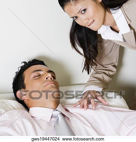 Portrait of a businesswoman bending over a businessman sitting on a couch View Large Photo Image Picture - Portrait of a businesswoman bending over a businessman sitting on a couch. Fotosearch