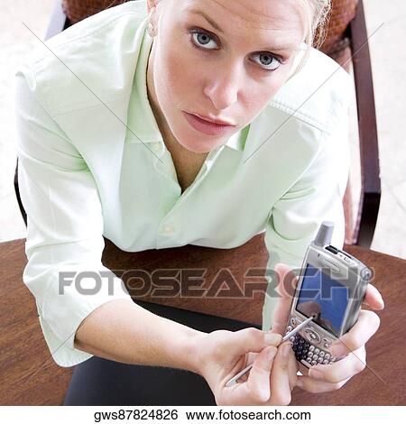 Stock Photograph - Portrait of a businesswoman holding a mobile phone. Fotosearch