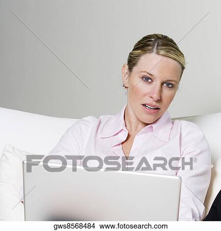 Portrait of a businesswoman sitting on the bed holding a laptop View Large Photo Image Picture - Portrait of a businesswoman sitting on the bed holding a laptop. Fotosearch