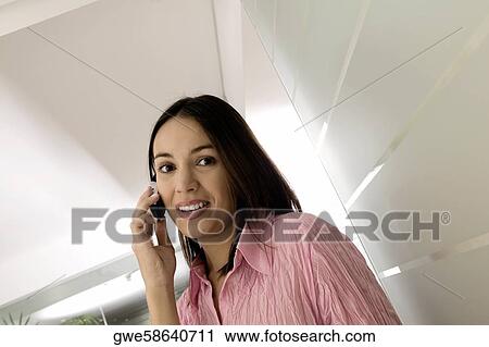 Stock Image - Portrait of a businesswoman using a mobile phone. Fotosearch