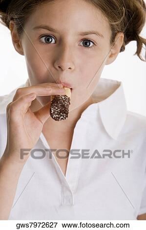 Portrait of a girl eating a pastry View Large Photo Image Stock Photo - Portrait of a girl eating a pastry. Fotosearch