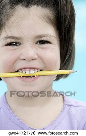 Portrait of a girl holding a pencil between her teeth View Large Photo Image Stock Photo - Portrait of a girl holding a pencil between her teeth. Fotosearch