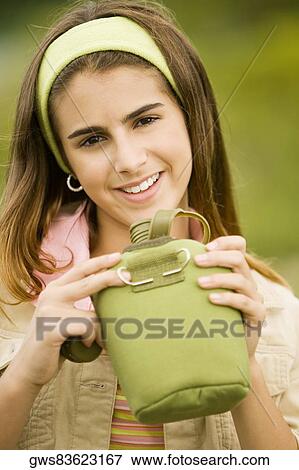Portrait of a girl holding a water bottle View Large Photo Image Stock Photo - Portrait of a girl holding a water bottle. Fotosearch