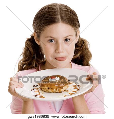 Portrait of a girl holding dessert in a plate View Large Photo Image Stock Photography - Portrait of a girl holding dessert in a plate. Fotosearch