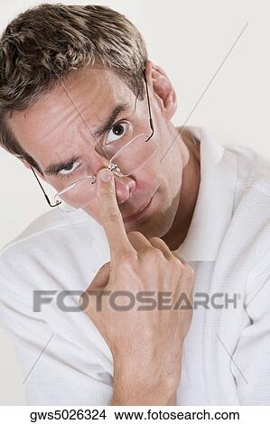 Portrait of a mid adult man adjusting his eyeglasses View Large Photo Image Picture - Portrait of a mid adult man adjusting his eyeglasses. Fotosearch