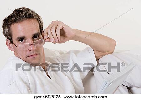 Portrait of a mid adult man adjusting his eyeglasses View Large Photo Image Stock Photography - Portrait of a mid adult man adjusting his eyeglasses. Fotosearch