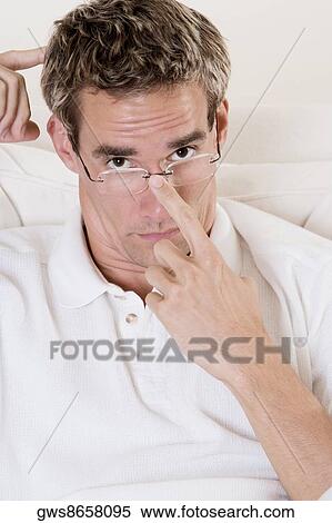Portrait of a mid adult man adjusting his eyeglasses View Large Photo Image Stock Photography - Portrait of a mid adult man adjusting his eyeglasses. Fotosearch