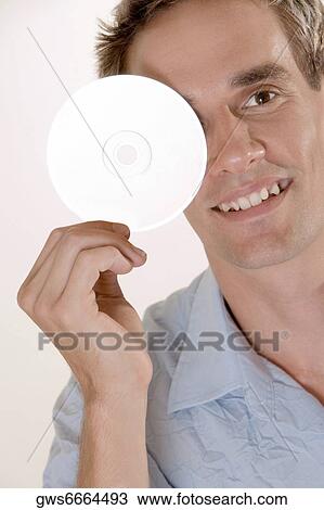 Portrait of a mid adult man covering his eye with a CD View Large Photo Image Stock Image - Portrait of a mid adult man covering his eye with a CD. Fotosearch