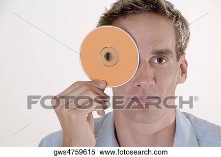Portrait of a mid adult man covering his eye with a CD View Large Photo Image Stock Photography - Portrait of a mid adult man covering his eye with a CD. Fotosearch