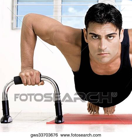 Stock Photograph - Portrait of a mid adult man doing push-ups. Fotosearch