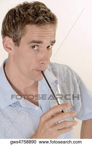 Portrait of a mid adult man drinking water with a straw View Large Photo Image Stock Image - Portrait of a mid adult man drinking water with a straw. Fotosearch