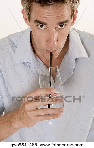 Portrait of a mid adult man drinking water with a straw View Large Photo Image Stock Photo - Portrait of a mid adult man drinking water with a straw. Fotosearch