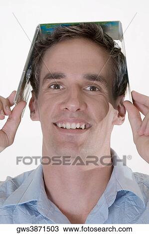 Portrait of a mid adult man holding a CD case on his head View Large Photo Image Stock Image - Portrait of a mid adult man holding a CD case on his head. Fotosearch
