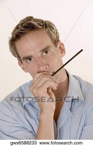 Portrait of a mid adult man holding a drinking straw close to his mouth View Large Photo Image Stock Image - Portrait of a mid adult man holding a drinking straw close to his mouth. Fotosearch