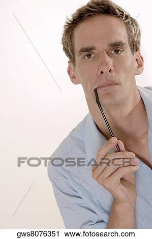 Portrait of a mid adult man holding a drinking straw View Large Photo Image Stock Image - Portrait of a mid adult man holding a drinking straw. Fotosearch
