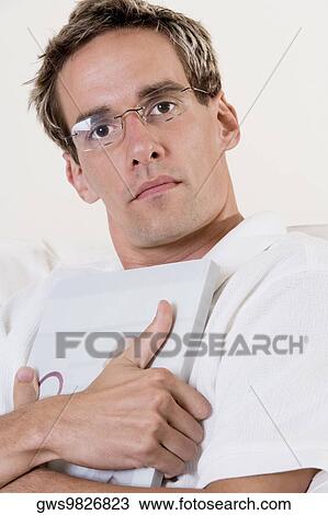 Stock Image - Portrait of a mid adult man holding a book. Fotosearch