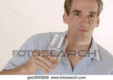 Portrait of a mid adult man holding a glass of water View Large Photo Image Stock Photo - Portrait of a mid adult man holding a glass of water. Fotosearch