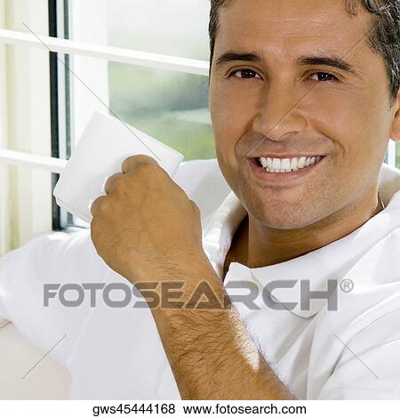 Stock Photo - Portrait of a mid adult man holding a cup. Fotosearch