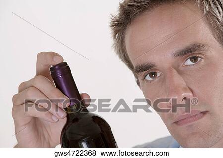 Portrait of a mid adult man holding a bottle of red wine View Large Photo Image Stock Photo - Portrait of a mid adult man holding a bottle of red wine. Fotosearch