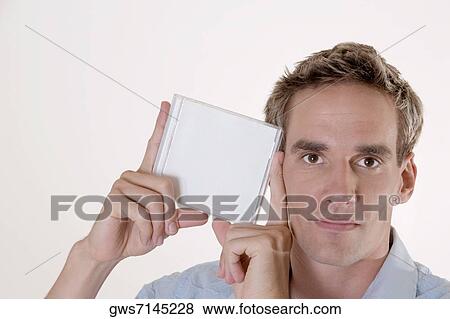 Portrait of a mid adult man holding a CD case View Large Photo Image Stock Photo - Portrait of a mid adult man holding a CD case. Fotosearch
