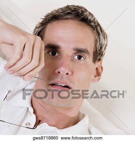Portrait of a mid adult man holding his eyeglasses View Large Photo Image Stock Image - Portrait of a mid adult man holding his eyeglasses. Fotosearch