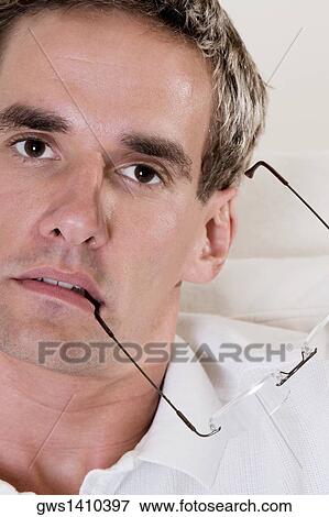 Portrait of a mid adult man holding his eyeglasses View Large Photo Image Stock Photo - Portrait of a mid adult man holding his eyeglasses. Fotosearch