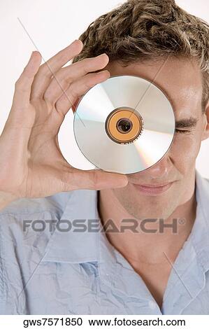 Portrait of a mid adult man peeking through a CD View Large Photo Image Stock Image - Portrait of a mid adult man peeking through a CD. Fotosearch