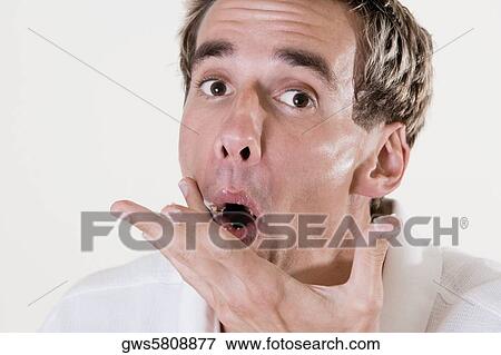 Stock Photo - Portrait of a mid adult man wiping his mouth. Fotosearch
