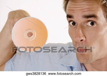 Stock Photograph - Portrait of a mid adult man with a CD on his finger. Fotosearch