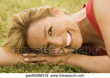 Portrait of a mid adult woman lying on the grass View Large Photo Image Stock Photo - Portrait of a mid adult woman lying on the grass. Fotosearch