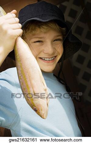 Portrait of a teenage boy holding a fish View Large Photo Image Stock Image - Portrait of a teenage boy holding a fish. Fotosearch