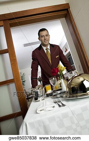 Portrait of a waiter serving food View Large Photo Image Stock Photo - Portrait of a waiter serving food. Fotosearch