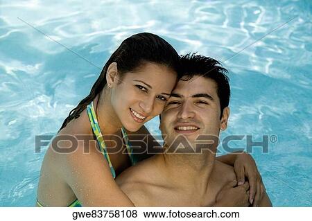 Stock Photo - Portrait of a young couple smiling in a swimming pool. Fotosearch