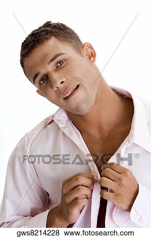 Portrait of a young man buttoning his shirt View Large Photo Image Stock Photo - Portrait of a young man buttoning his shirt. Fotosearch