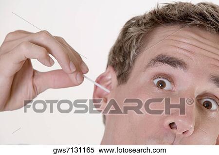 Portrait of a young man cleaning his ear with a cotton swab View Large Photo Image Stock Photography - Portrait of a young man cleaning his ear with a cotton swab. Fotosearch