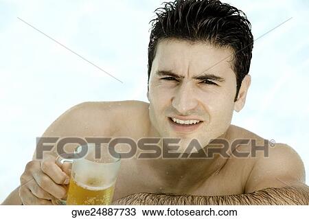 Portrait of a young man holding a mug of beer View Large Photo Image Stock Image - Portrait of a young man holding a mug of beer. Fotosearch