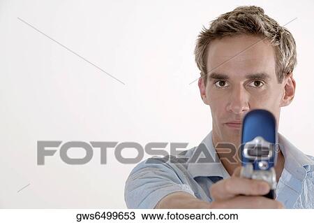 Portrait of a young man holding a mobile phone View Large Photo Image Stock Image - Portrait of a young man holding a mobile phone. Fotosearch