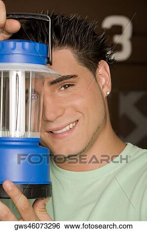 Portrait of a young man holding a lantern View Large Photo Image Stock Photograph - Portrait of a young man holding a lantern. Fotosearch