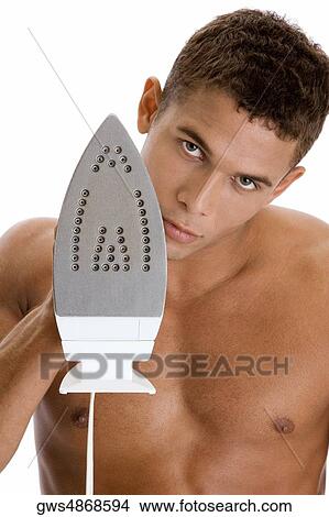 Picture - Portrait of a young man holding an iron. Fotosearch