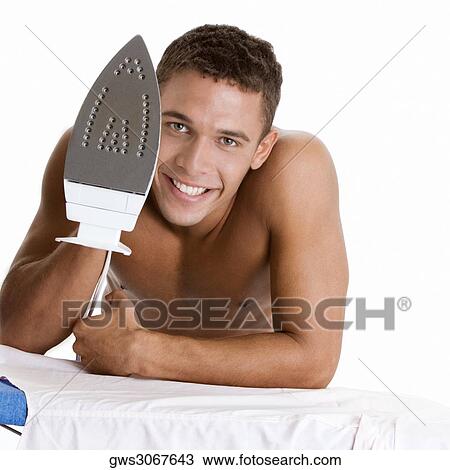 Portrait of a young man holding an iron View Large Photo Image Stock Image - Portrait of a young man holding an iron. Fotosearch
