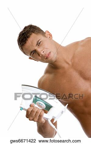 Portrait of a young man holding an iron View Large Photo Image Stock Image - Portrait of a young man holding an iron. Fotosearch