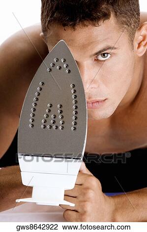 Portrait of a young man holding an iron View Large Photo Image Stock Image - Portrait of a young man holding an iron. Fotosearch