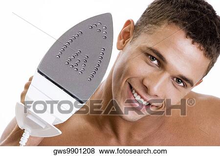 Portrait of a young man holding an iron View Large Photo Image Stock Photo - Portrait of a young man holding an iron. Fotosearch