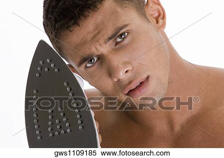Portrait of a young man holding an iron View Large Photo Image Stock Photography - Portrait of a young man holding an iron. Fotosearch