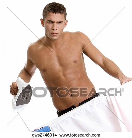 Portrait of a young man ironing his shirt View Large Photo Image Picture - Portrait of a young man ironing his shirt. Fotosearch