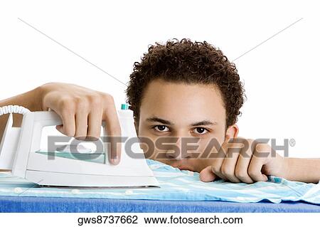 Stock Image - Portrait of a young man ironing. Fotosearch